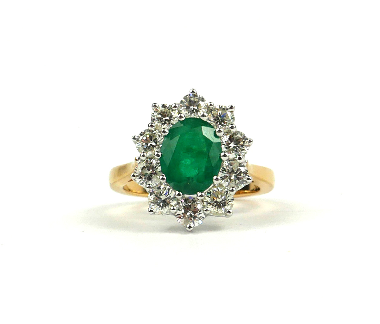 AN 18CT YELLOW GOLD OVAL EMERALD AND DIAMOND CLUSTER RING. (Approx Emerald 1.60ct, Diamonds 1.50ct)