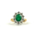 AN 18CT YELLOW GOLD OVAL EMERALD AND DIAMOND CLUSTER RING. (Approx Emerald 1.60ct, Diamonds 1.50ct)