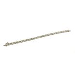A LARGE 9CT WHITE GOLD DIAMOND LINE BRACELET set with alternate sets of baguette cut and round