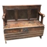 A 17TH/18TH CENTURY OAK SETTLE With panelled back above scrolling arms, having a hinged seat. (h