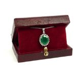 AN 18CT WHITE GOLD PENDANT, set with a large oval emerald surrounded by a halo of round brilliant