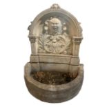 A DECORATIVE PAINTED STONE WATER FOUNTAIN The arch top with central facial mask surrounded foliage