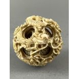 A CONCENTRIC IVORY DRAGON PUZZLE BALL, 19TH CENTURY. W: 4.5cm