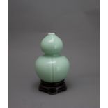 A Celadon double gourd Jar, Qing dynasty or later H: 15.8cm,wood stand of slightly compressed