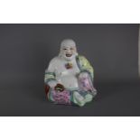 A large Chinese hand painted porcelain buddha figure, C 1962. H:27cm A laughing buddha in a floral