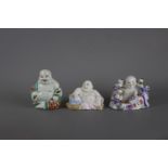 Three Chinese porcelain laughing buddhas, 19th / 20th century. H: 12cm The tallest is decorated with