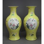 A Pair of yellow ground 'famille rose' Vases, Qing Dynasty H: 43.5 cms D: 20 cms of slender baluster