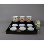 A tea ceremony set including a tray, three tea cups, six small dishes, a tea caddy, and a tea