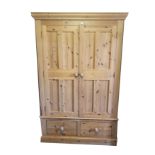 A PINE DOUBLE WARDROBE With fielded panelled doors above two drawers. (126cm x 58cm x 198cm)