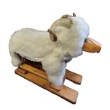 A 1980'S MODEL OF A ROCKING RAM COVERED IN WHITE FUR With blue eyes, raised on rectangular pine