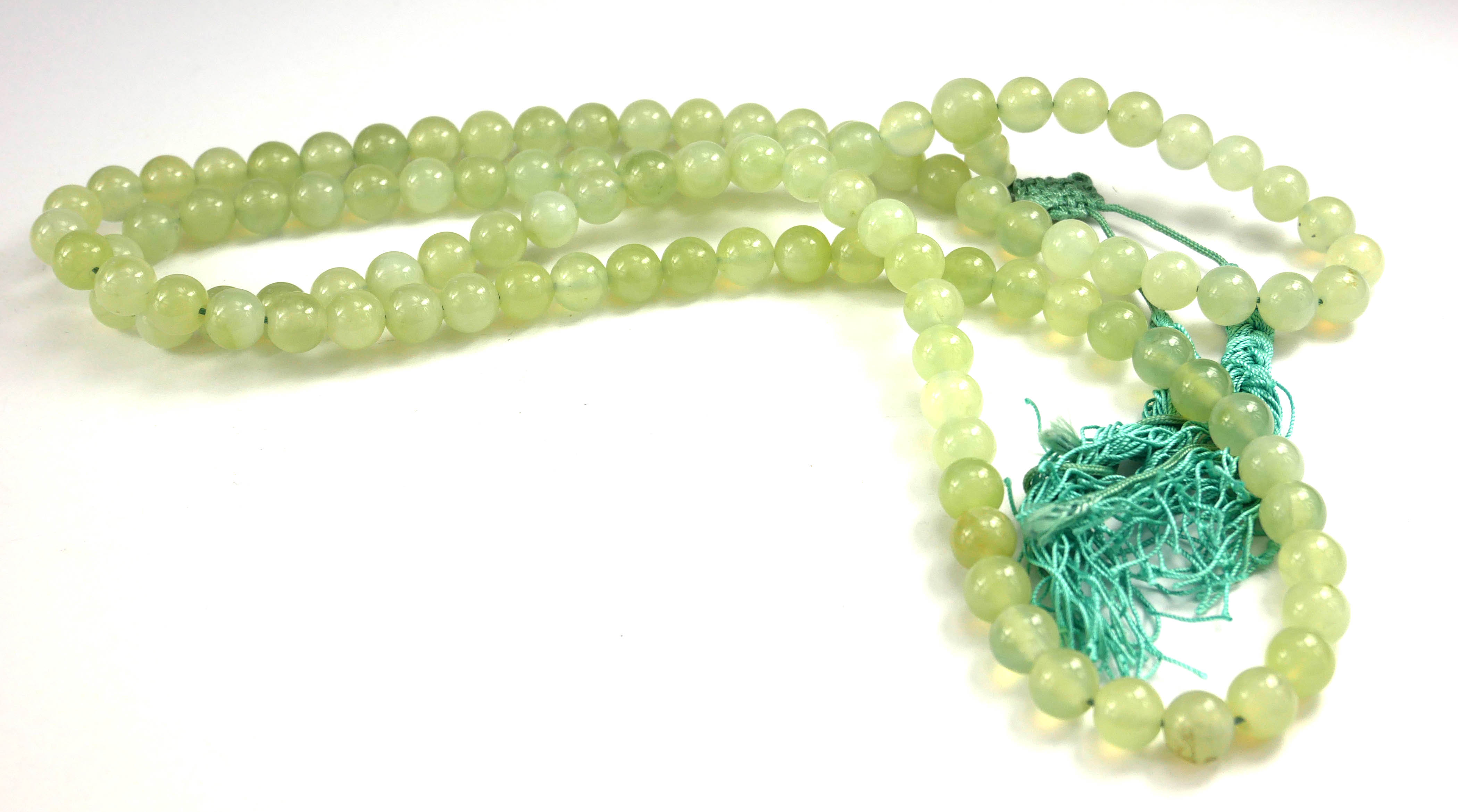A CHINESE LIGHT GREEN JADE NECKLACE Made with 109 spherical beads, with a dangling turquoise silk