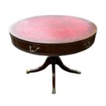 A REGENCY STYLE MAHOGANY DRUM TABLE Having a tooled red leather surface and an arrangement of real
