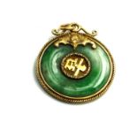 A VINTAGE CHINESE YELLOW METAL AND JADE PENDANT Circular carved jade roundel set with inscription