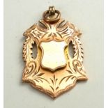 AN EARLY 20TH CENTURY 9CT GOLD WATCH FOB Pierced shield form with hanging bale. (approx 4cm x 2.5cm,