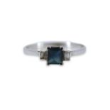 A WHITE METAL, SAPPHIRE AND DIAMOND RING The central square cut sapphire flanked to either side by