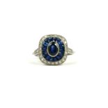 A PLATINUM ART DECO STYLE, SAPPHIRE AND DIAMOND RING The central oval cut sapphire surrounded by a