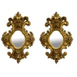 A PAIR OF 19TH CENTRY CONTINENTAL CARVED GILTWOOD MIRRORS decorated with facial mask