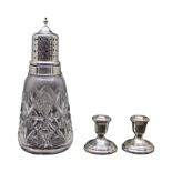 A SILVER TOPPED CUT GLASS SUGAR SIFTER Along with a pair of novelty silver candlesticks, sugar