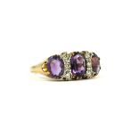 A 9CT YELLOW GOLD OVAL AMETHYST AND DIAMOND RING.