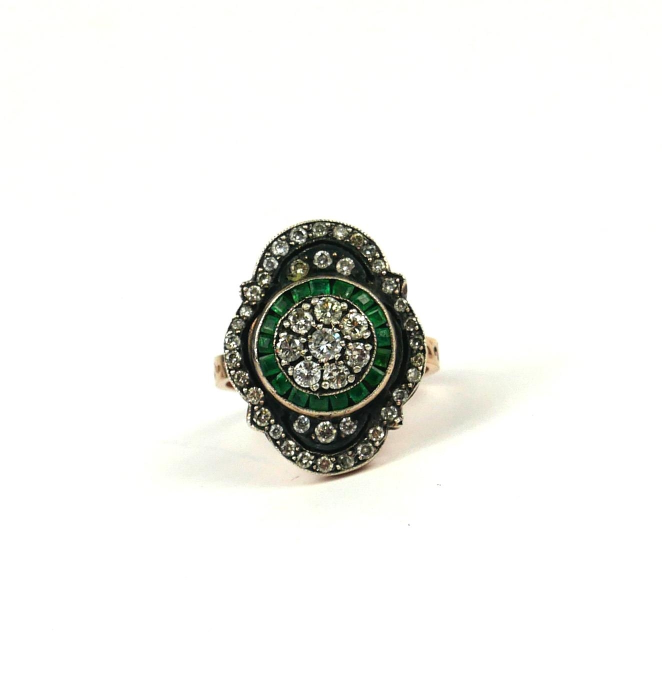 A VINTAGE STYLE 8CT ROSE GOLD (SILVER TOP) RING set with round diamonds and emeralds.