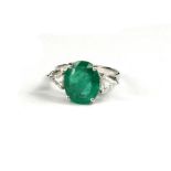 AN 18CT WHITE GOLD, OVAL CUT EMERALD AND ROSE CUT BRILLIANT CUT DIAMOND TRILOGY RING with WGI