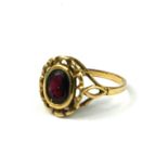 A 9CT GOLD AND GARNET RING Having an open work mount. (gross weight 2.2g, size M½)