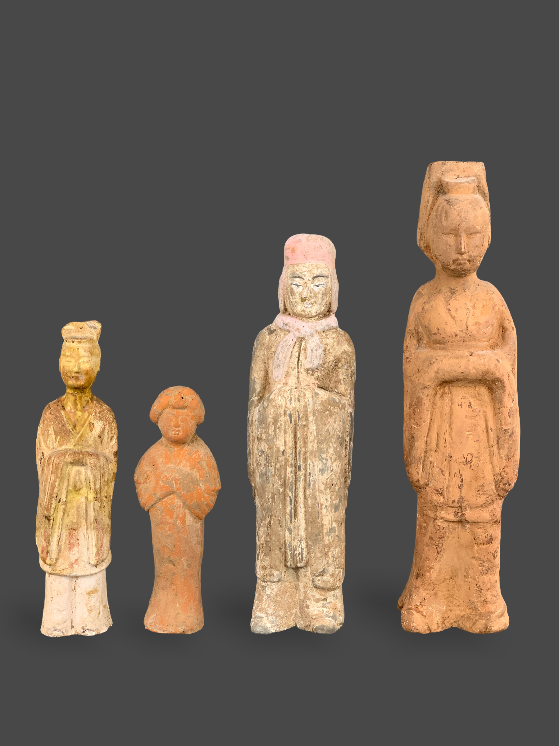 A GROUP OF FOUR POTTERY FIGURES, 4TH/5TH CENTURY Including three figures of officials, one of them