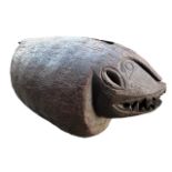 AN 18TH/19TH CENTURY CARVED WOODEN SLIT WAR DRUM Having a stylised zoomorphic carved face.