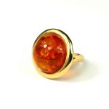 A LARGE 14CT GOLD AND CABOCHON AMBER RING Large central round Baltic amber approximately 20mm,