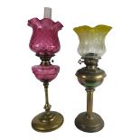 A VICTORIAN CRANBERRY GLASS OIL LAMP With slim solid brass column and base, together with another