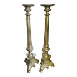 A PAIR OF LARGE CONTINENTAL FLOOR STANDING ECCLESIASTICAL GILDED BRASS ALTAR CANDLESTICKS On