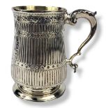 A GEORGIAN SILVER TANKARD Having a single scrolled handle, ribbed decoration and central