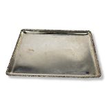 AN EDWARDIAN SILVER RECTANGULAR TRINKET TRAY With scrolled border, hallmarked Mappin and Webb,