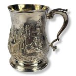 A GEORGIAN SILVER TANKARD Having a single scrolled handle and embossed decoration of a tavern