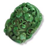 A LARGE CARVED JADE PENDANT In natural green, decorated with flora and fauna on both sides. (11cm