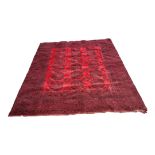 AN EARLY 20TH CENTURY AFGHAN BOKHARA WOOLEN CARPET With red/burgundy ground, the field with offset