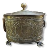 A 19TH CENTURY CONTINENTAL BRASS AND COPPER OVAL LOG BIN Embossed to one side with mythological