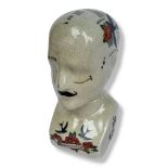 A CERAMIC PHRENOLOGY TATTOO HEAD Together with another one, with a cream crackle glaze, bearing