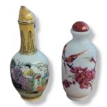 TWO EARLY 20TH CENTURY CHINESE PORCELAIN SNUFF BOTTLES A baluster form bottle painted with an exotic