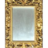 A 19TH CENTURY FLORENTINE PIERCED AND CARVED GILTWOOD FRAMED MIRROR. (43cm x 57cm) Condition: good