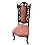 A VICTORIAN ROSEWOOD AND MAHOGANY NURSING CHAIR Having a pierced fret and upholstered back, on