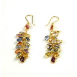 A PAIR OF YELLOW METAL AND COLOURED SAPPHIRE EARRINGS Having an arrangement of oval cut stones. (
