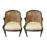 A PAIR OF EARLY 20TH CENTURY MAHOGANY BERGÈRE TUB ARMCHAIRS With carved rams head arms, on turned