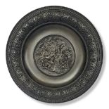 A CAST BRONZE ROMAN SCENE ROUND WALL PLAQUE/CHARGER Depicting Romans admiring and serving a Roman