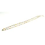 A YELLOW METAL AND COLOURED SAPPHIRE NECKLACE Having a strand of oval cut sapphire. (approx total