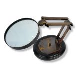 A LIBRARY MAGNIFYING GLASS ON ADJUSTABLE STAND Bearing the name Watts & Sons Ltd. (h 30cm)