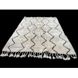 A LARGE MOROCCAN STYLE WOOL BERBER RUG With a thick shag pile, black zigzag pattern over a cream