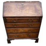 A GEORGIAN MAHOGANY BUREAU With fitted interior above four drawers, applied with brass swan neck