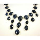 A LARGE SILVER AND SAPPHIRE NECKLACE Having an arrangement of faceted oval and pear cut stones. (