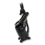 A FOLK ART HAND CARVED WOODEN KANGAROO WINE BOTTLE HOLDER/POURER with an ebonised finish. (h 48cm)